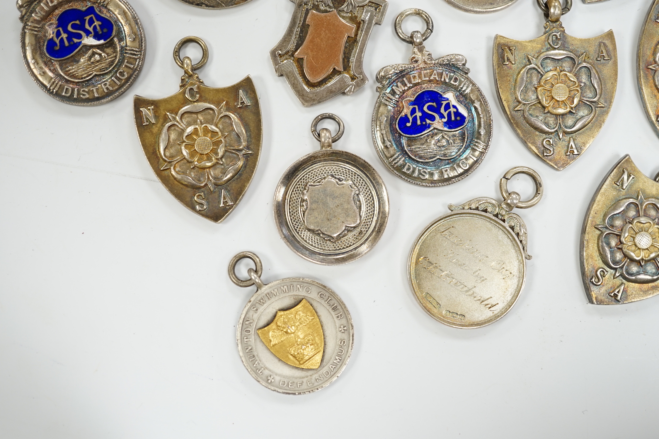 Twelve assorted mainly mid 20th century silver medals, including running and swimming (three with enamel) and two other white metal medals.